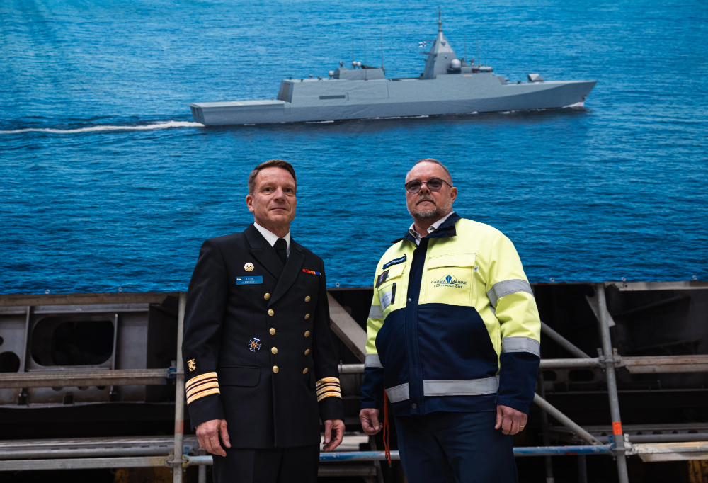 Björn Enroth ja Timo Ståhlhammar seisovat lakanan edessä, jossa on kuva Pohjanmaa-luokan aluksesta.