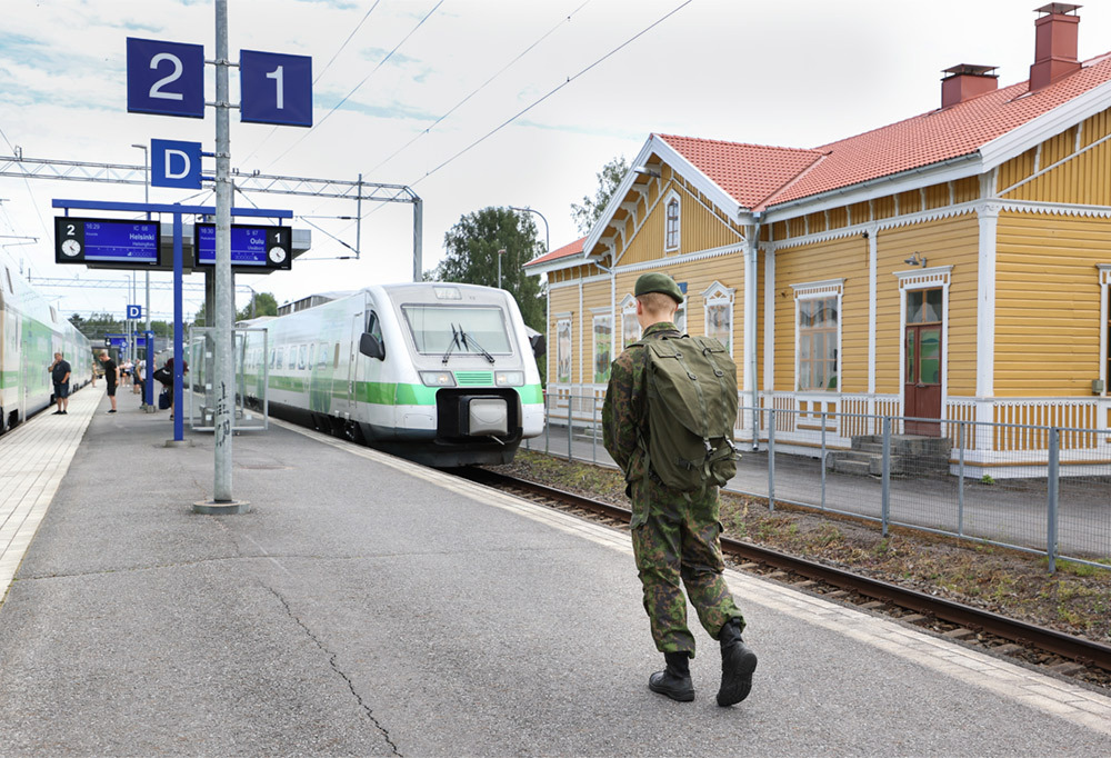 Kuvassa varusmies rautatieasemalla.