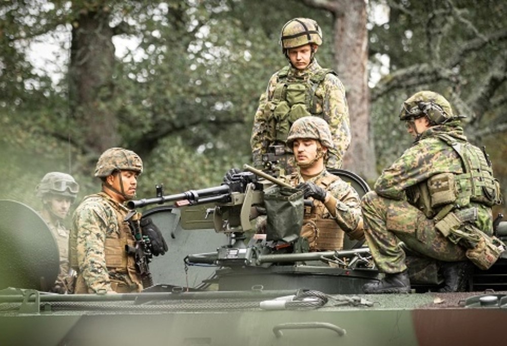 Kuvassa suomalaiset ja yhdysvaltalaiset sotilaat tutkivat kalustoa yhdessä.