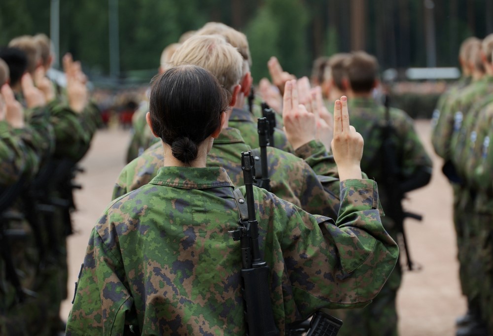 Varusmiehet seisovat selät kameraan päin ja antavat sotilasvalan.