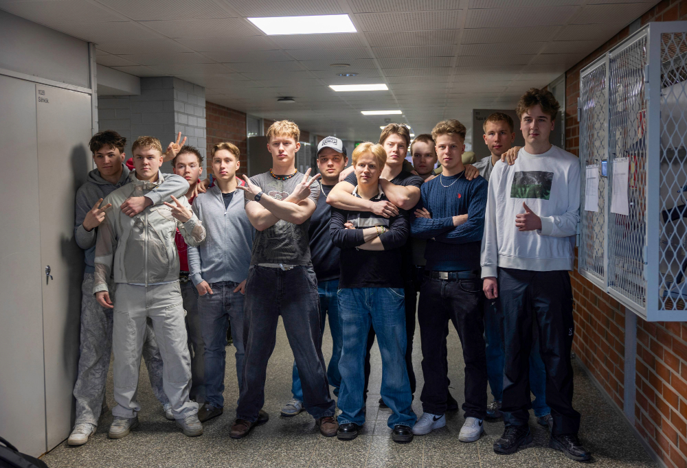 Kuvassa kotiutuneet sotilaspoliisit poseeraavat siviilivaatteissa rivissä.