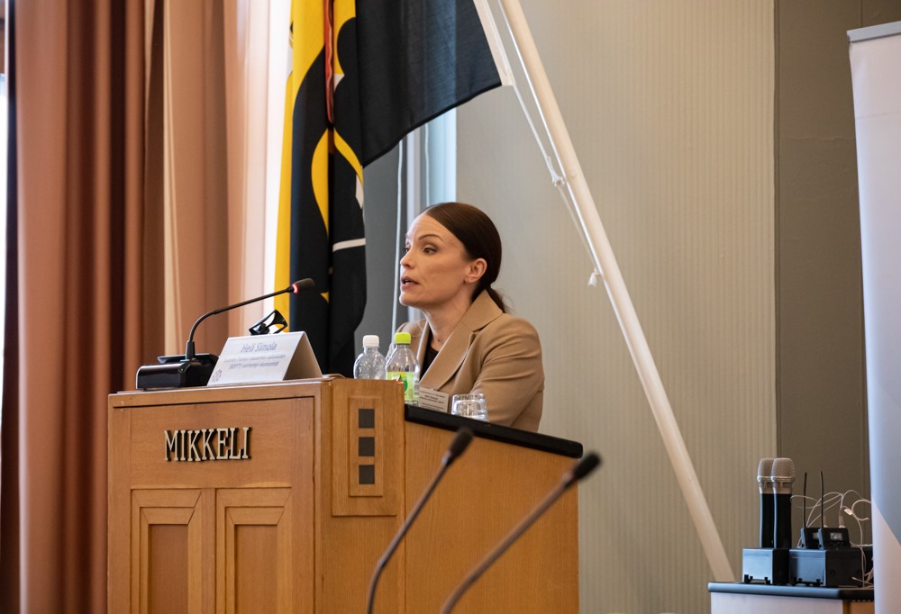 Haastateltava kuvassa puhuja korokkeella